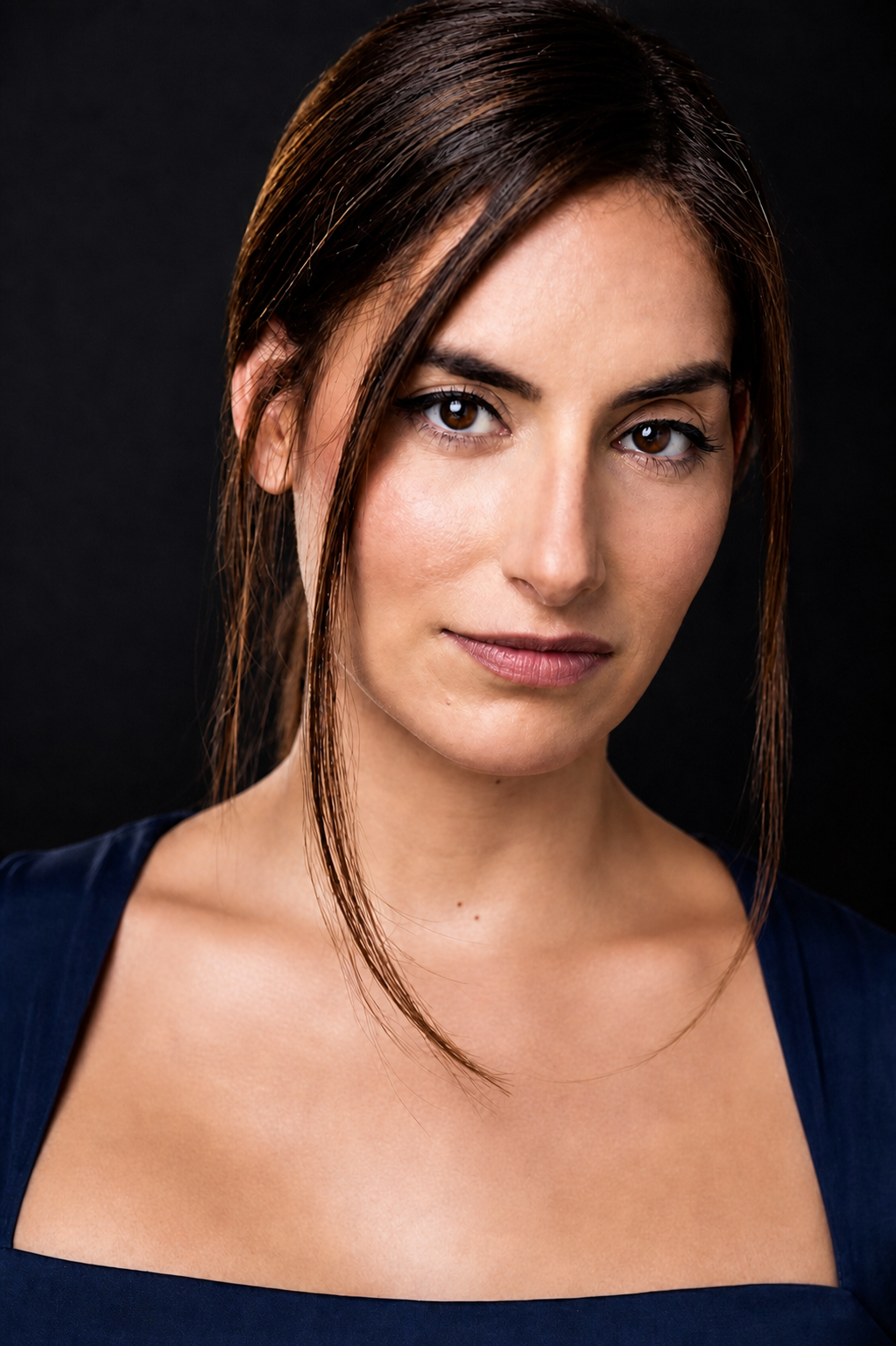 Maria Sky in a vibrant navy-blue acting headshot against a dark studio background